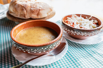 Enjoy a traditional Balkan soup, featuring tender pork and cabbage in a creamy broth, served with...