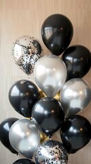 Fototapeta premium Shiny black and silver balloons with confetti patterns.