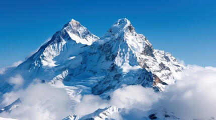 Obraz premium Twin snow-capped peaks stand tall amidst surrounding clouds, creating a dramatic and awe-inspiring panorama that captures the essence of nature's untamed majesty and tranquility.