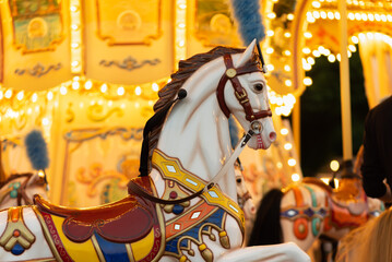 White horse on a children's carousel. Attractions and entertainment.