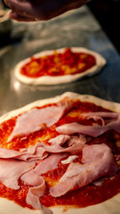 pizza maker hands pour ingredients into a pizza dough