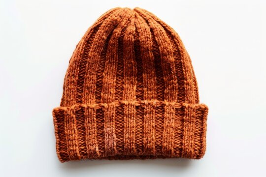 A knitted wool hat in deep orange lying flat, isolated on a white background