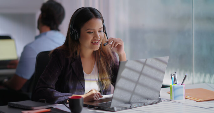 Indian Asian Hindu busy gen z lady woman sitting use laptop talk speak client online indoor office young adult cute female girl staff worker expert agent do work day task look screen call centre job