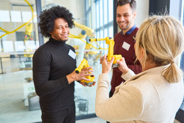 Group of engineers discussing robotic gripper arm during training session