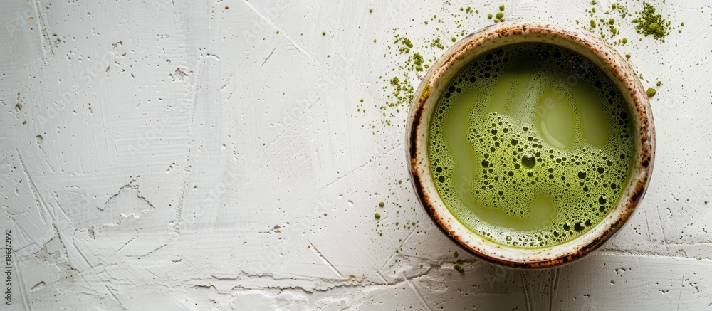 Aufkleber Bird s eye view of a cup filled with matcha green tea on a blank white surface with space for text or other elements creating a copy space image