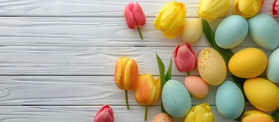 Obraz premium Top view of a spring themed scene featuring vibrant eggs yellow tulips and copy space on white wood