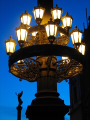 Pillar with beautiful retro lanterns. Beautiful lanterns on a pole in the evening Prague