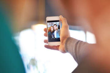 Sharing the moment. Shot of a young couple taking a photo of themselves while on a date at a cafe.