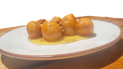 loukoumades with honey in the plate