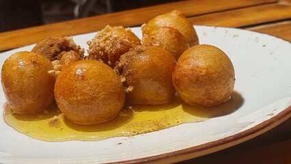 loukoumades with honey in the plate