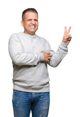 Middle age arab man wearing sport sweatshirt over isolated background smiling with happy face winking at the camera doing victory sign. Number two.