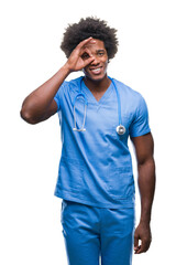 Afro american surgeon doctor man over isolated background doing ok gesture with hand smiling, eye looking through fingers with happy face.