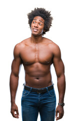 Afro american shirtless man showing nude body over isolated background smiling looking side and staring away thinking.