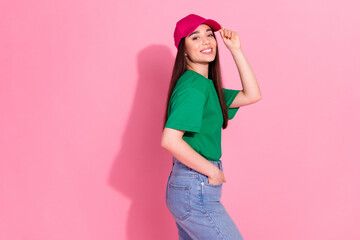 Photo of shiny attractive lady dressed green t-shirt pink headwear smiling empty space isolated pink color background