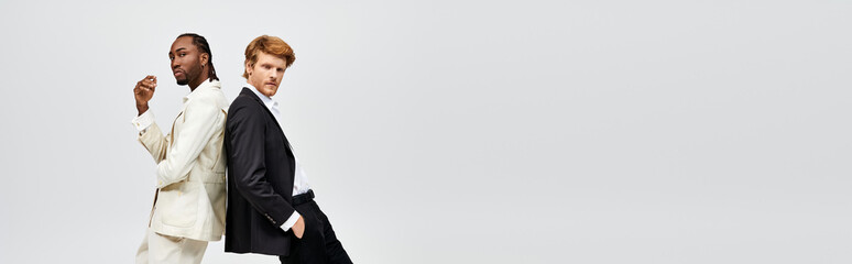 Two multicultural men in elegant suits walking confidently side by side.