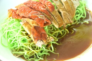 Chinese jade noodles topping slice rosted duck dressing sweet soy sauce on plate