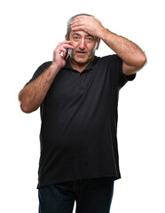 Fototapeta premium Handsome senior man talking on smartphone over isolated background stressed with hand on head, shocked with shame and surprise face, angry and frustrated. Fear and upset for mistake.