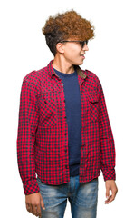 Young handsome man with afro hair wearing sunglasses looking away to side with smile on face, natural expression. Laughing confident.