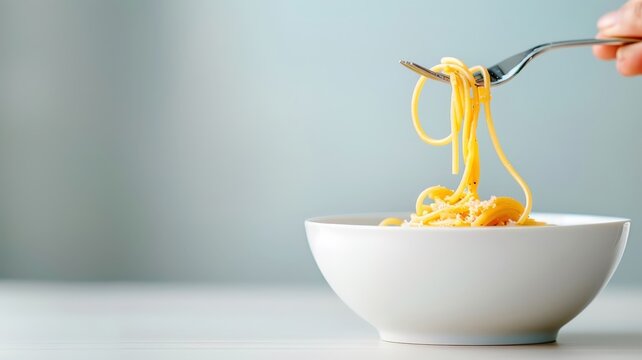 A minimalist composition of a single spaghetti strand twirling around a fork.