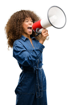 African american woman wearing blue jumpsuit communicates shouting loud holding a megaphone, expressing success and positive concept, idea for marketing or sales