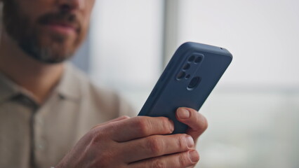 Businessman browsing smartphone application in home closeup. Guy looking cell