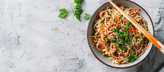 Directly above shot of instant soba noodles garnished with scallions carrots and sauce with chopsticks and a perfect copy space image