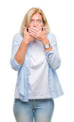 Middle age blonde woman over isolated background shocked covering mouth with hands for mistake. Secret concept.