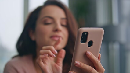 Happy brunette watching smartphone in living room closeup. Dreamy woman get sms