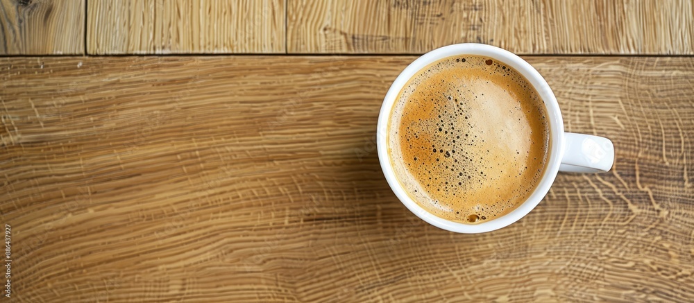 Leinwandbilder Coffee with milk in a white cup placed on a wooden surface with space for text or images. with copy space image. Place for adding text or design