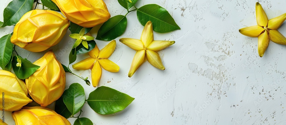 Poster flat lay composition of tasty carambola fruits and leaves against a white backdrop with copy space i