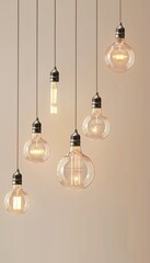 hanging LED lights at different heights against a plain wall