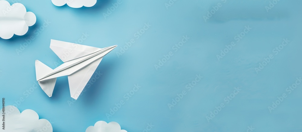 Aufkleber top view of white paper origami airplane on pastel blue background with clouds suitable for copy spa