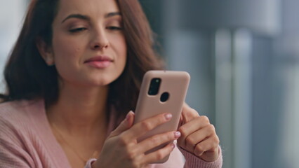 Fototapeta premium Relaxed woman reading cellphone at modern kitchen closeup. Carefree girl weekend