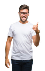 Young handsome man wearing glasses over isolated background doing happy thumbs up gesture with hand. Approving expression looking at the camera with showing success.