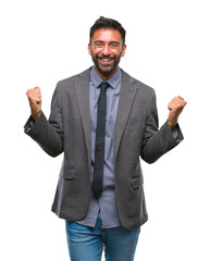 Adult hispanic business man over isolated background celebrating surprised and amazed for success with arms raised and open eyes. Winner concept.
