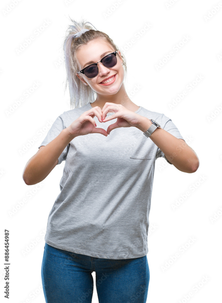 Canvas Prints Young blonde woman wearing sunglasses over isolated background smiling in love showing heart symbol and shape with hands. Romantic concept.