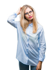 Young beautiful blonde business woman wearing glasses over isolated background confuse and wonder about question. Uncertain with doubt, thinking with hand on head. Pensive concept.