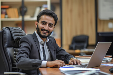 Obraz premium Happy Pakistani Man Working on Laptop in Office