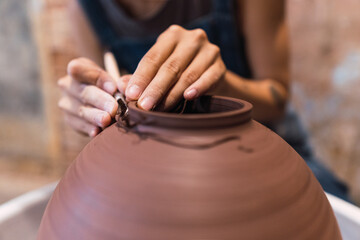 Sculptor hands working in pottery objects in a ceramic shop. Hand-made concept