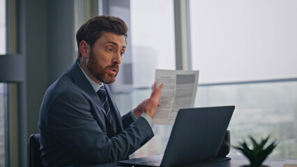 Angry boss speaking web conference in office closeup. Manager pointing papers
