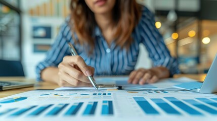 Fototapeta premium Businesswoman analyzing financial reports and statistics at the office desk. Professional working on data analysis and market research.