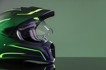 Modern motorcycle helmet with visor on mirror surface against grey background. Space for text