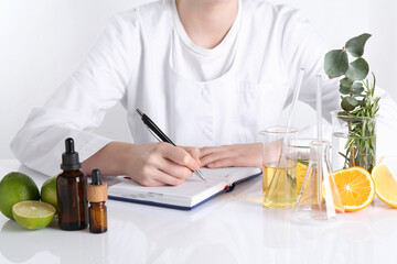 Aromatherapy product. Scientist developing essential oils at white table in laboratory, closeup