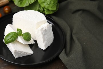 Fresh ricotta (cream cheese) and basil on table, closeup. Space for text