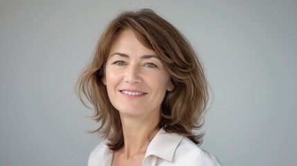 Smiling MiddleAged French Woman with Brown Hair in a White Blouse for Professional Portrait, Stock Photography