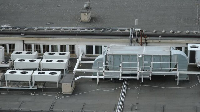 Air conditioning, central ventilation systems on roof of building, pan right. Air recovery, purification to maintain healthy microclimate, save energy. Equipment blocks with vertirators, metal pipes.