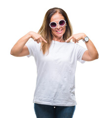 Middle age hispanic woman wearing fashion sunglasses over isolated background looking confident with smile on face, pointing oneself with fingers proud and happy.