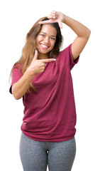 Young beautiful brunette woman over isolated background smiling making frame with hands and fingers with happy face. Creativity and photography concept.