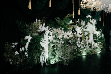 Elegant wedding decoration with a floral plant theme that is very lush like a forest. with a very romantic black background