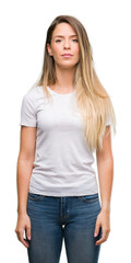 Beautiful young woman wearing t-shirt and jeans with a confident expression on smart face thinking serious